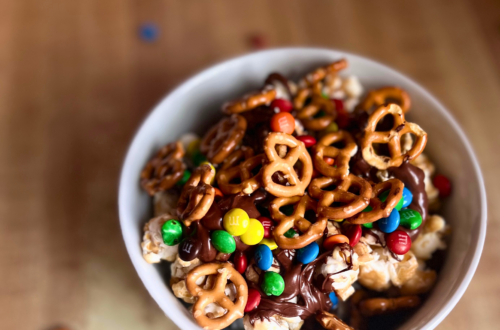 A Sweet and Salty Popcorn Bowl consisting of layers of caramel corn, chocolate drizzle, mimi M&Ms and mini pretzels.
