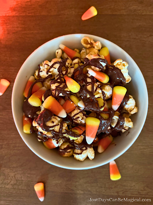 This Disney-inspired Candy Corn Popcorn bowl layered with caramel corn, candy corn, and chocolate drizzle, is the perfect Halloween movie night snack!
