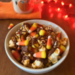 Disney-inspired Candy Corn Popcorn bowl is layered with caramel corn, candy corn, and chocolate drizzle.