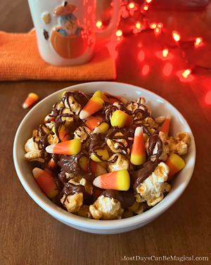 Disney-inspired Candy Corn Popcorn bowl is layered with caramel corn, candy corn, and chocolate drizzle.