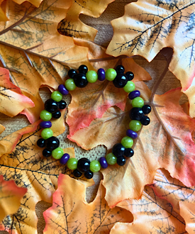How to make a DIY Disney-inspired purple, Green & black Halloween stretch bracelet featuring Mickey-shaped focal beads.
