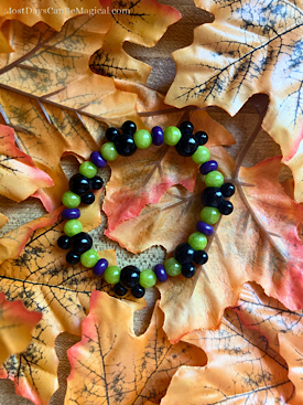 How to make a DIY Disney-inspired purple, Green & black Halloween stretch bracelet featuring Mickey-shaped focal beads.
