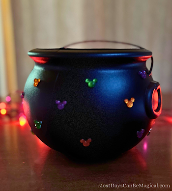 Disney-inspired black cauldron with Halloween-colored Mickey-shaped rhinestones hot glued to it - a magical DIY craft.