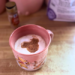 Chai latte in a pink Winnie the Pooh mug topped with a Mickey-shaped design in the foam.