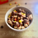Disney-inspired peanut butter and chocolate caramel popcorn bowl topped with mini peanut butter cups and Reese's pieces.