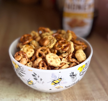 Honey Cereal Snack Mix in an adorable bowl with bees and foliage.