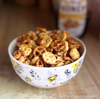 Honey Cereal Snack Mix in an adorable bowl with bees and foliage.