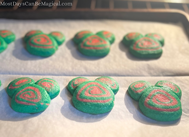 Red and green Disney-inspired Christmas pinwheel cookies baking in the oven.