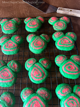 Red and green Disney-inspired Christmas pinwheel cookies cooling on a rack.