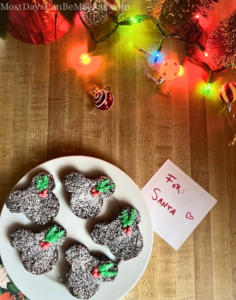 A white plate of Disney-inspired brownies with Mickey-shaped holly berries with leaves.