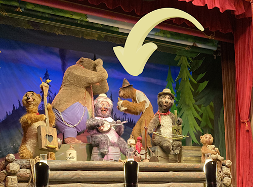 The Country Bear Jamboree band playing their instruments on a stage with a red curtain.
