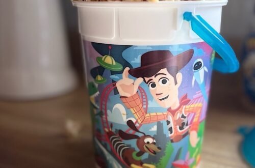 Homemade Sweet & Salty Maple Popcorn overflowing from the top of a popcorn bucket featuring Woody and other Toy Story characters.